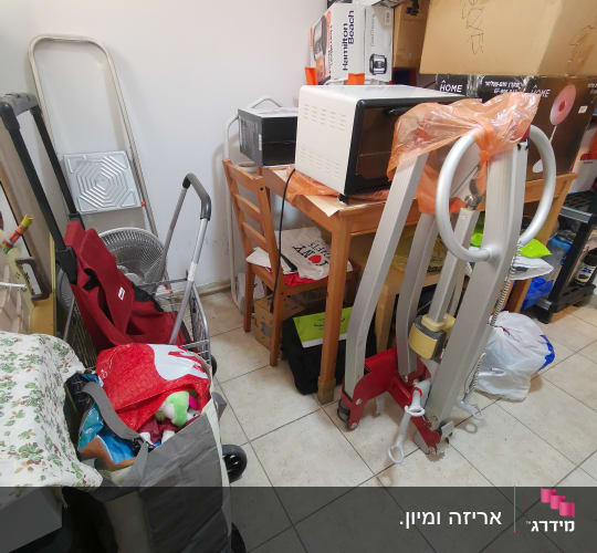 חדר אחסון עם קופסאות, תנור קטן וסולם מתקפל